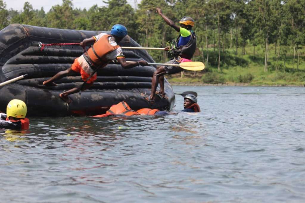 People falling off a raft into a rapid